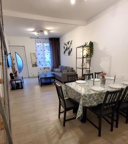 une salle à manger avec une table et des chaises et un salon dans l'établissement Maison de ville Marcq en Baroeul, à Marcq-en-Barœul