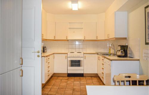 a kitchen with white cabinets and a stove top oven at Beautiful Home In Tingsryd With Sauna in Tingsryd