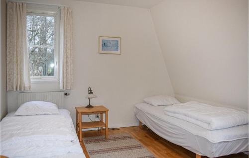 two beds in a room with a window at Beautiful Home In Tingsryd With Sauna in Tingsryd