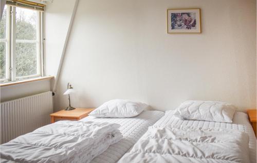 a bedroom with two beds and a table and a window at Beautiful Home In Tingsryd With Sauna in Tingsryd