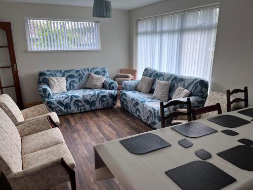 a living room with a couch and a table at Spacious 5 double bed bedroom bungalow near Belfast in Lisburn