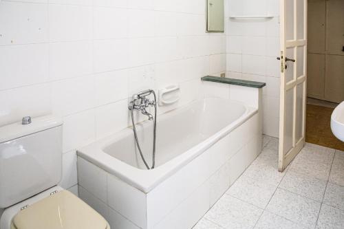 a white bathroom with a tub and a toilet at Honoré de Balzac in Alghero
