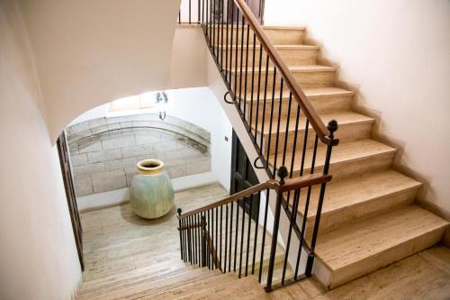 a staircase with a vase sitting on the floor at Honoré de Balzac in Alghero