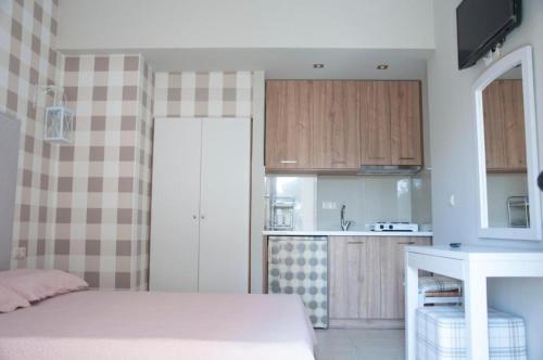 a bedroom with a bed and a small kitchen at Ariadnes Holiday Accommodation in Apidias Lakos