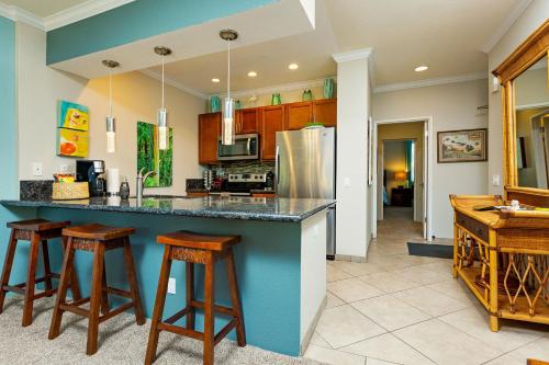 a kitchen with a blue counter and stools at Cool & Quiet Wailea Oasis, Big Lanai + Two Pools in Wailea