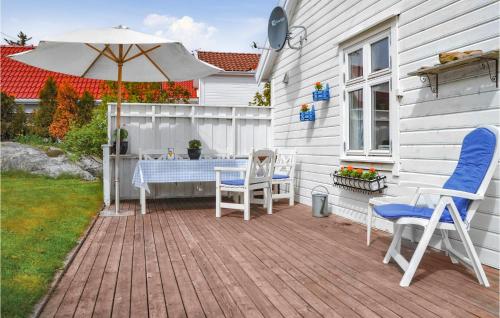 a patio with two chairs and an umbrella at Holiday Home Skudeneshavn Kvednadalen in Skudeneshavn