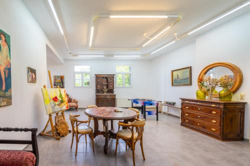 a living room with a table and chairs at Liogerma Art Deco Villa - 5 min drive to Lassi in Sarlata