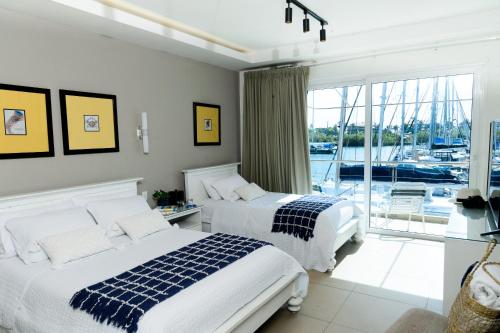 two beds in a bedroom with a view of a marina at Marina Hotel at Shelter Bay in Colón