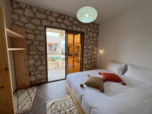 a bedroom with a bed with a teddy bear on it at Le Réel Kaouki in Sidi Kaouki