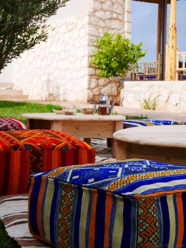 a group of colorful pillows sitting on a patio at Le Réel Kaouki in Sidi Kaouki