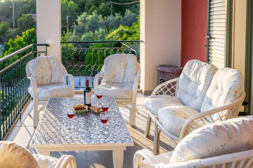 a patio with chairs and a table with glasses of wine at Liogerma Art Deco Villa - 5 min drive to Lassi in Sarlata