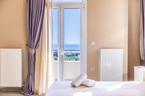 a bedroom with a bed with a view of the ocean at Liogerma Art Deco Villa - 5 min drive to Lassi in Sarlata
