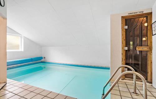 a swimming pool with blue water in a room at Cozy Home In Spøttrup With Sauna in Spottrup