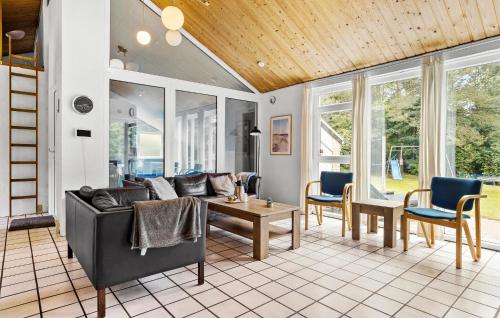 a living room with a couch and a table and chairs at Cozy Home In Spøttrup With Sauna in Spottrup
