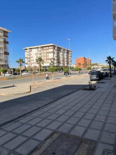 an empty street with cars parked in a parking lot at Appartement Haut standing-coralia,centre ville oujda in Oujda