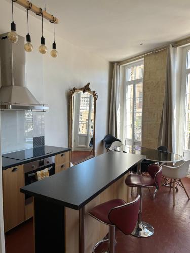 a kitchen with a black counter and some chairs at Historique vieux port in Marseille