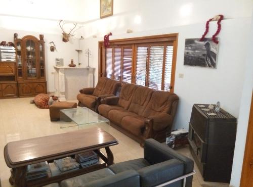 a living room with a couch and a tv at Castel Ashkelon in Ashqelon