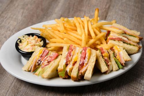 a white plate with a sandwich and french fries at Marina Hotel at Shelter Bay in Colón