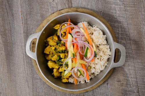 a pan of food with rice and vegetables on a table at Marina Hotel at Shelter Bay in Colón