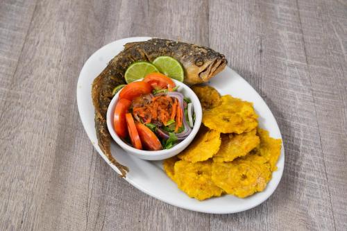 a plate of food with a fish and a bowl of vegetables at Marina Hotel at Shelter Bay in Colón