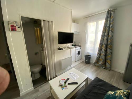 un petit salon avec des toilettes et une table dans l'établissement Studette 13m2, à Bagnolet