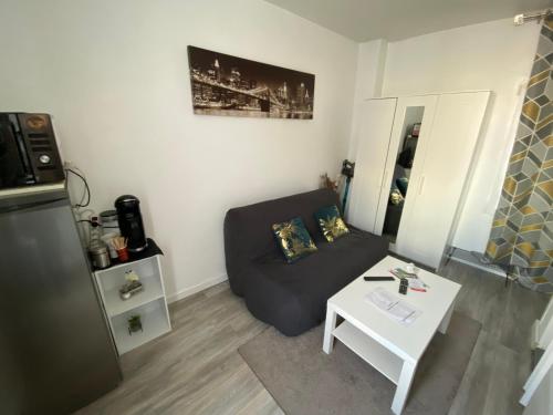 un petit salon avec un canapé et une table dans l'établissement Studette 13m2, à Bagnolet
