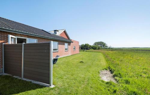 a house with a fence next to a field at Didde in Ribe