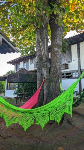 a hammock is tied to a tree at Pousada dos Veleiros in Nova Almeida