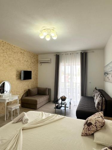 a bedroom with a bed and a couch and a television at Apartmens Xhenis Lux in Ulcinj
