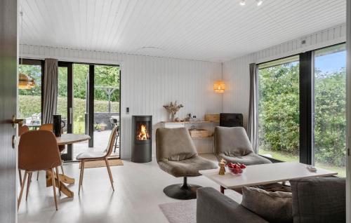 a living room with a fireplace and a table and chairs at 3 Bedroom Cozy Home In Vinderup in Vinderup