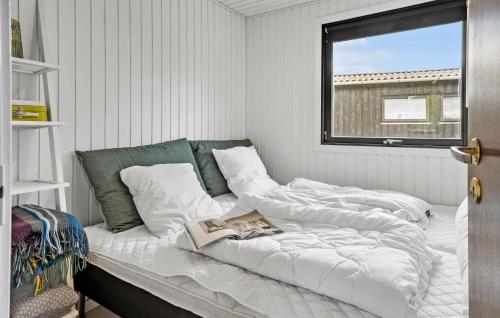 a bed with a book on it in a room at 3 Bedroom Cozy Home In Vinderup in Vinderup