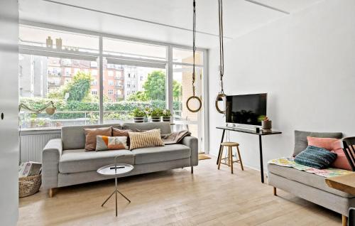 a living room with a couch and a tv at Nice Apartment In Frederiksberg C in Copenhagen