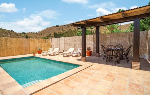 a patio with a pool and a table and chairs at Nice Home In Benajarafe With Wifi in Benajarafe