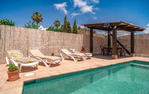 a swimming pool with chairs and a gazebo at Nice Home In Benajarafe With Wifi in Benajarafe