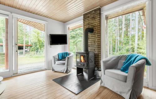a living room with a wood stove and two chairs at Pet Friendly Home In Kolind With Wifi in Kolind