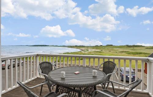 a table and chairs on a balcony with the ocean at Cozy Apartment In Bagenkop With Sauna in Bagenkop