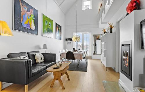 a living room with a black couch and a table at Cozy Apartment In Bagenkop With Sauna in Bagenkop