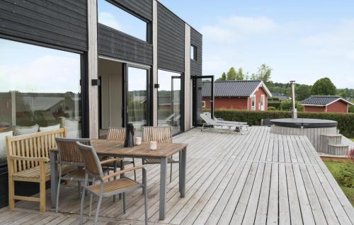 a wooden deck with a wooden table and chairs at 4 Bedroom Gorgeous Home In Sjølund in Sjølund