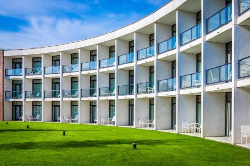 an exterior view of a building with a grass field at Nyborg Strand Hotel & Konference in Nyborg