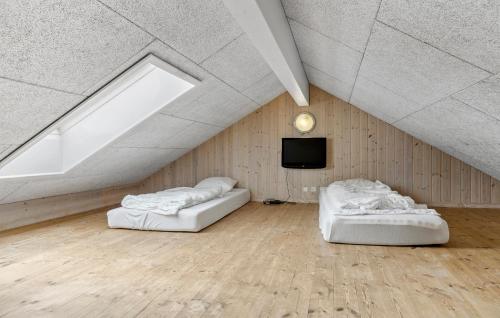 two beds in a room with a skylight and a television at Pet Friendly Home In Sydals With Sauna in Sønderby
