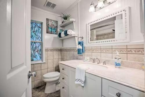 a bathroom with a sink and a toilet and a mirror at Charming 4-Bedroom Family Haven in Saint Augustine
