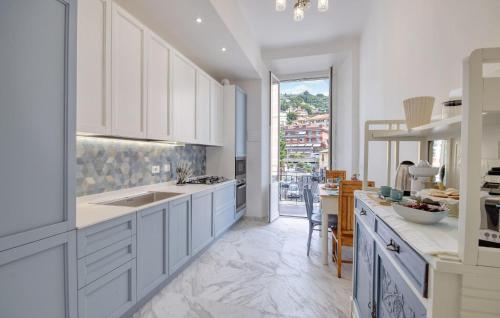 a kitchen with white cabinets and a large window at Casa Maria Paola in Santa Margherita Ligure