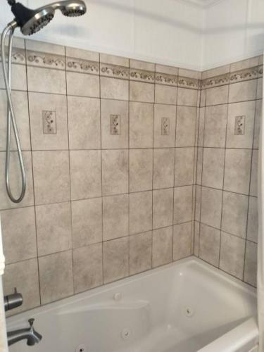 a bath tub with a shower head in a bathroom at Charming 4-Bedroom Family Haven in Saint Augustine