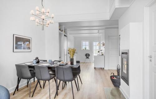 a dining room with a table and black chairs at Pet Friendly Apartment In Bagenkop in Bagenkop
