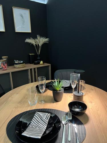 a wooden table with black plates and wine glasses at Tussia in Brindisi