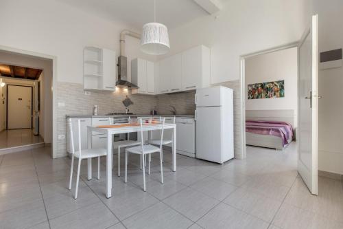 eine Küche mit weißen Geräten sowie einem Tisch und Stühlen in der Unterkunft Duomo Apartment in Florenz