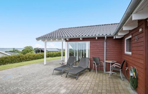 a patio with chairs and a table and a house at 3 Bedroom Awesome Home In Faaborg in Fåborg
