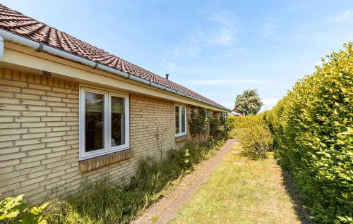 a house with a yard next to a building at Beautiful Home In Østermarie With Wifi in Østermarie