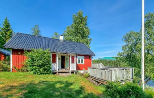 a red house on a hill with a yard at 3 Bedroom Cozy Home In Mellerud in Mellerud