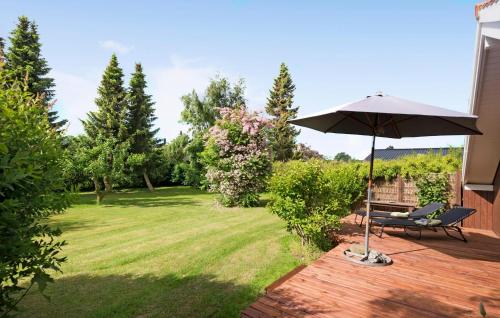 a patio with an umbrella and a bench at Cozy Home In Rødvig Stevns With Wifi in Rødvig